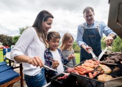 Happy family cooking a barbecue outdoors