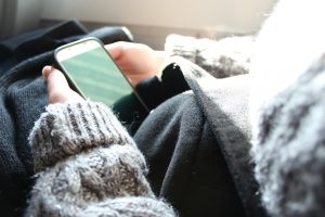 woman in sweater with phone