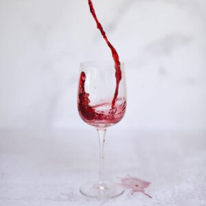 red wine spilling unto tablecloth