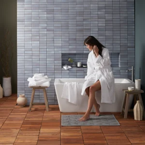 woman in luxury robe by a bathtub
