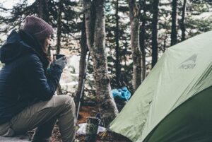 Woman with coffee mug camping